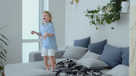 dos niños pequeños saltando en el sofá y divirtiéndose. alegría, risa y diversión en casa