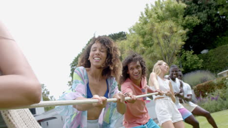 diverse group of friends enjoy a tug of war game outdoors