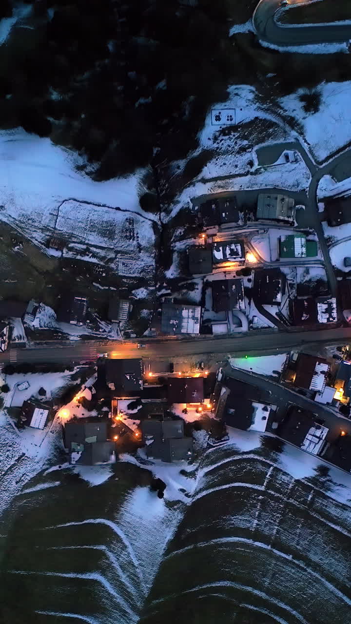 Aerial drone view of the Selva di Cadore comune illuminated at night in the province of Belluno, Dolomites, Italy. Vertical