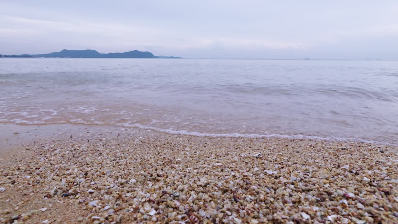 Experience the serene beauty of gentle waves washing over a sandy beach evoking a sense of calm and nature's tranquility.