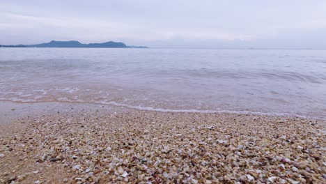 experience the serene beauty of gentle waves washing over a sandy beach evoking a sense of calm and nature's tranquility.