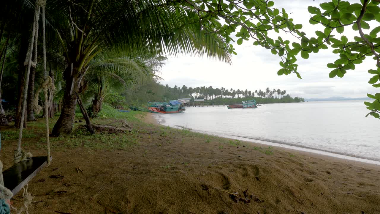 columpio de madera colgando de un árbol en la playa