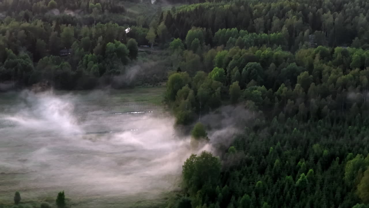 Аэросъемка телеобъективом с дрона, наклон над туманным полем, летний вечер в скандинавских странах