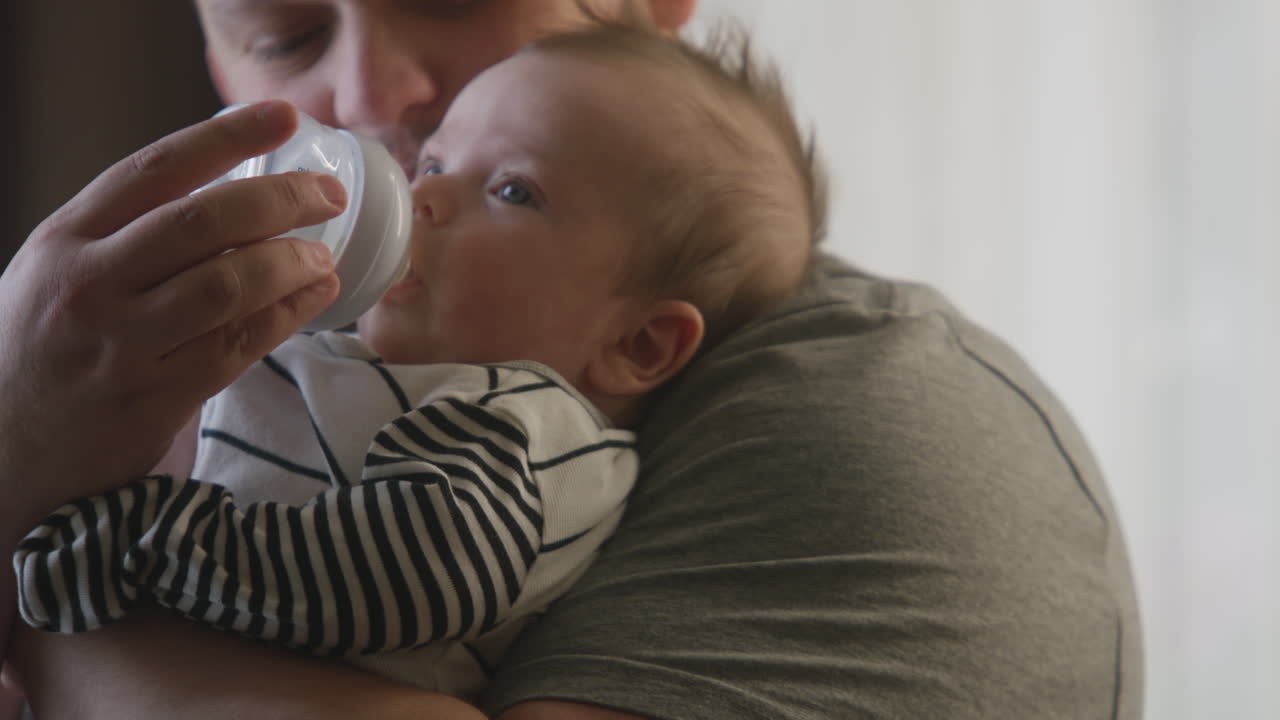Father feeding baby with a bottle