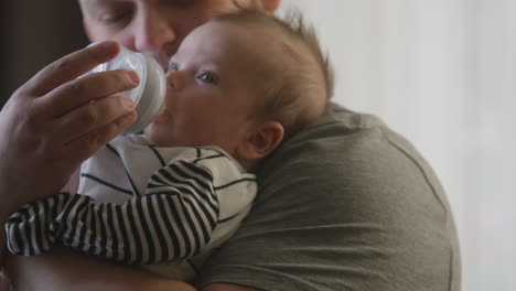 father feeding baby with a bottle