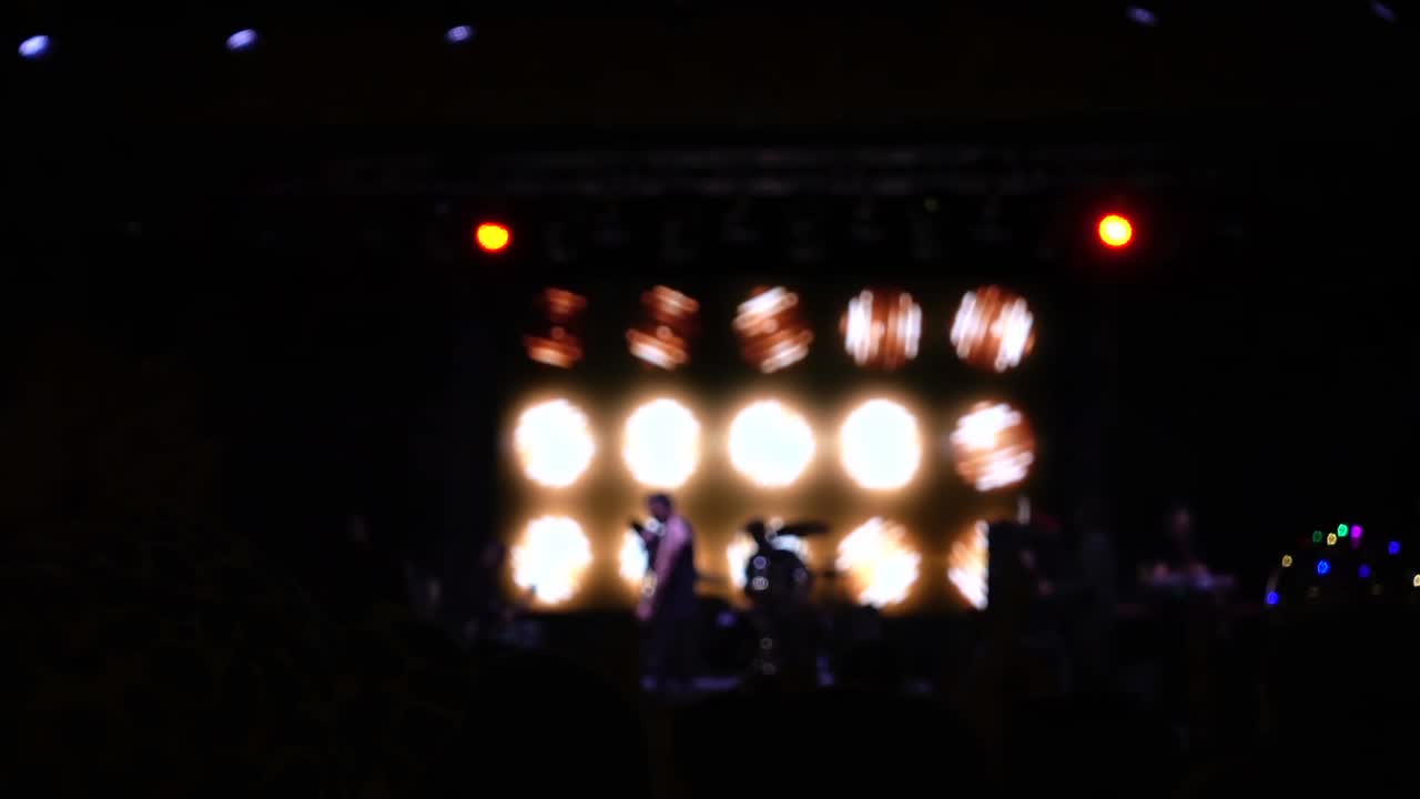 Koncert på scenen. Menneskemængde og musikere på scenen. Uskarpt.