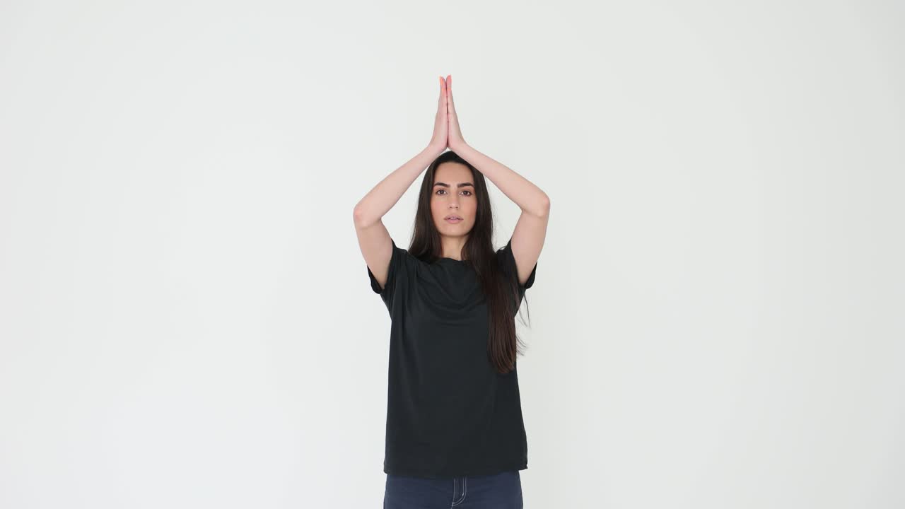 Woman in yoga prayer position with arms raised
