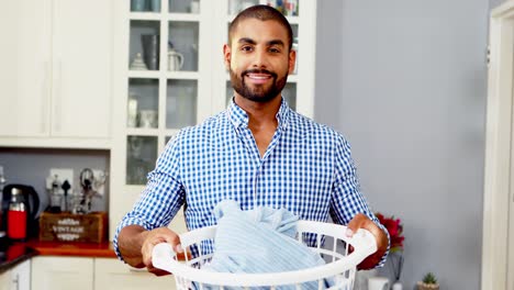 Portrait-of-happy-man-holding-bucket-full-of-clothes-4k