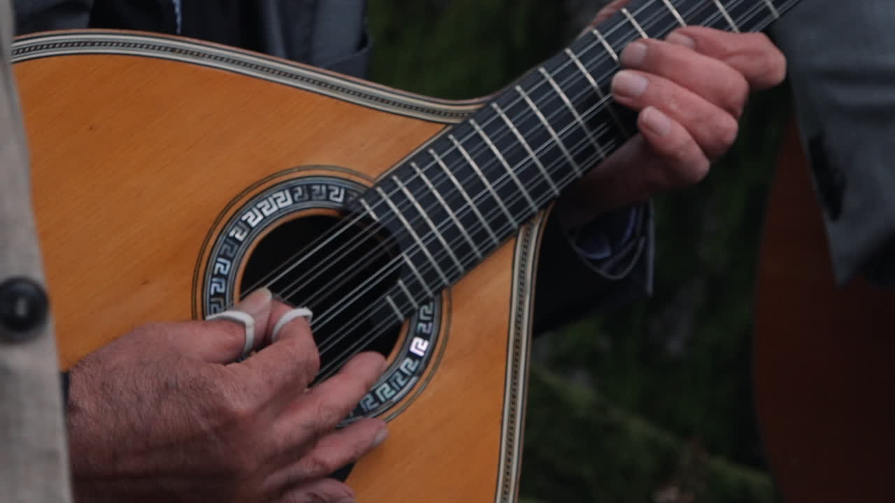 tocando una guitarra portuguesa al aire libre.