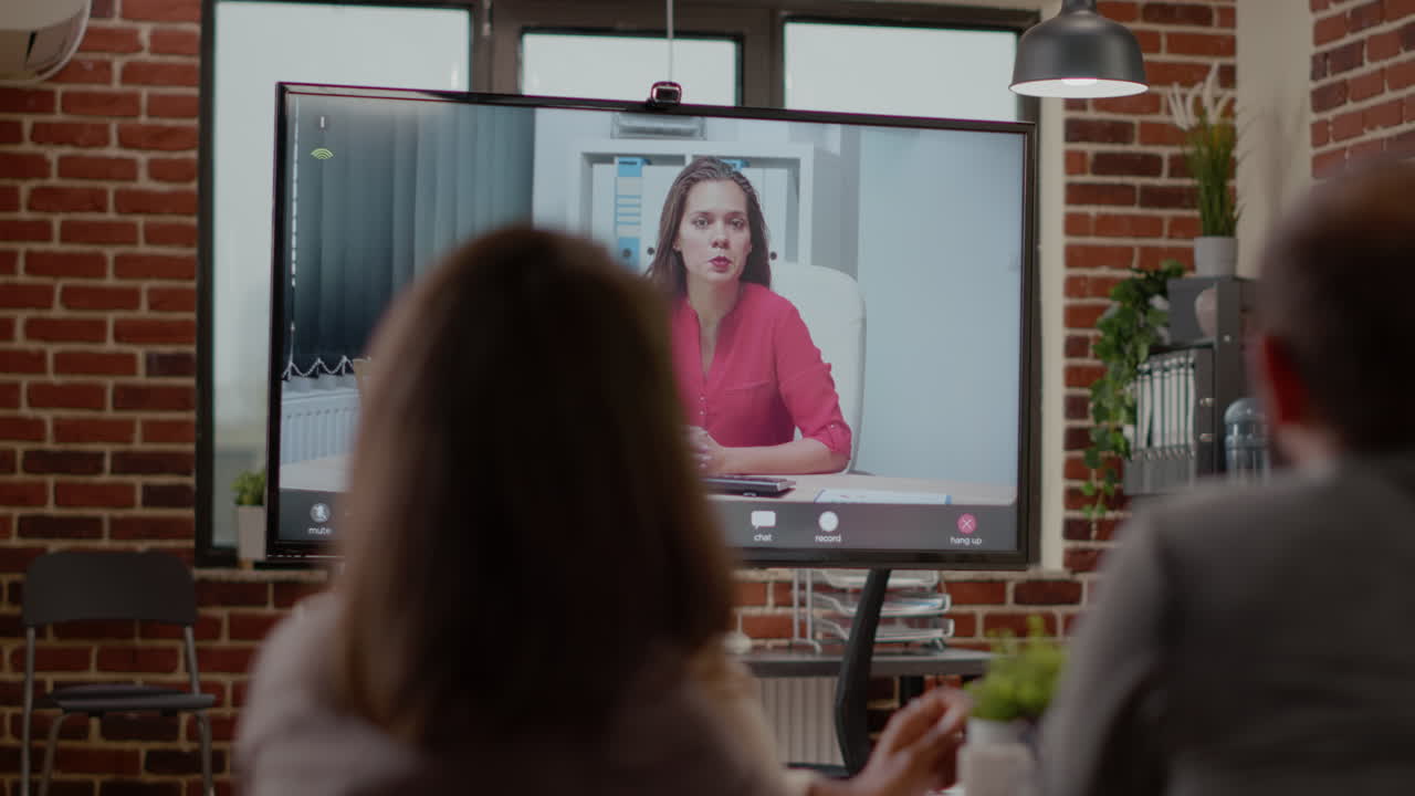 Close up of workmates talking on online video call with woman