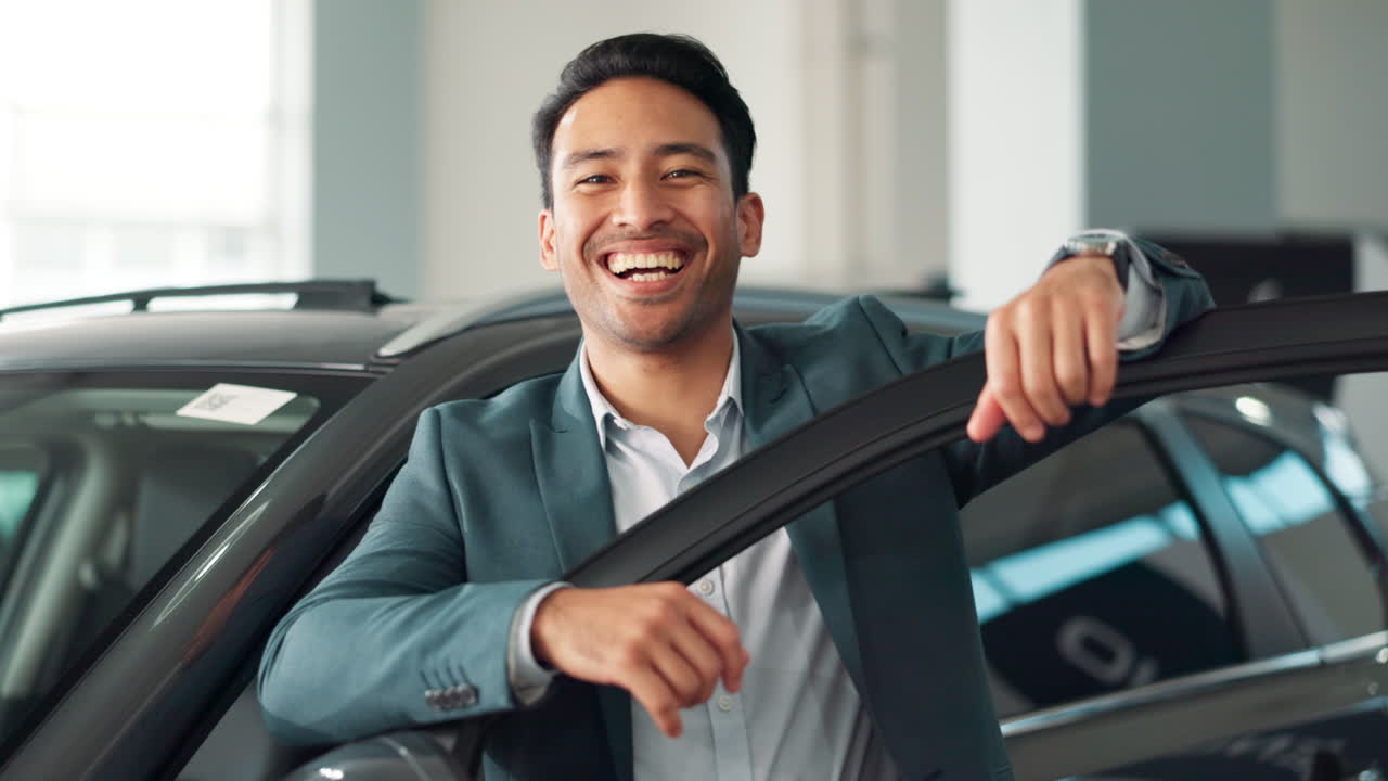 Happy businessman with new car at dealership