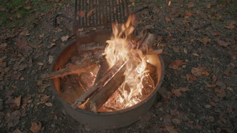 Breite-Zeitlupenaufnahmen-Eines-Feuers-In-Einem-Feuerring-Auf-Einem-Campingplatz