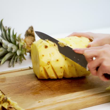 hands slicing pineapple