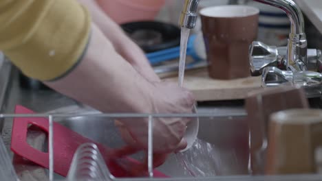 Washing-dishes-above-stainless-steel-sink