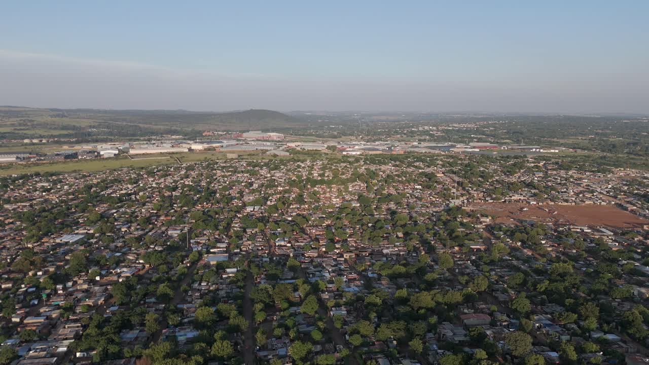 In questa breve clip aerea in 4K, la telecamera effettua una leggera svolta a destra, rivelando la vasta estensione di un insediamento rurale adiacente alle aree industriali di Pretoria, Sudafrica.