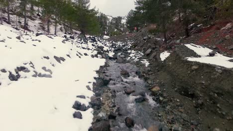 drone shots of stream and small waterfalls created by melting snow in troodos mountain cyprus