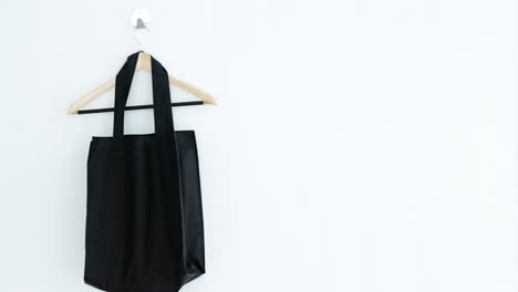 handbag and hanger hanging on white wall