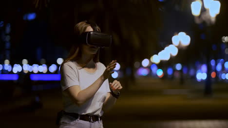 a young girl in virtual reality glasses in a large metropolis simulates work in the program game virtual reality interface. the concept of augmented reality