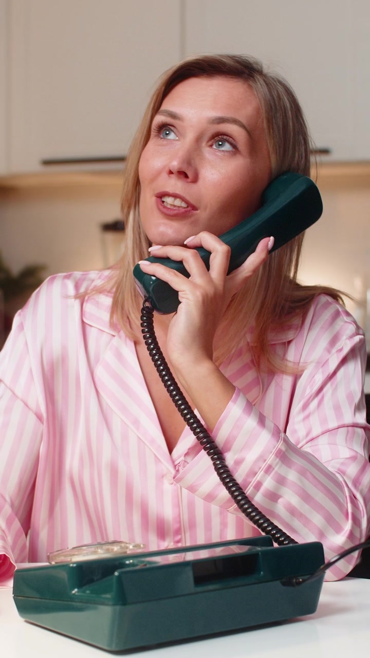 Operatrice di hotline adulta con telefono fisso retrò che ascolta, chiede, chiarisce e trova una soluzione stasera.