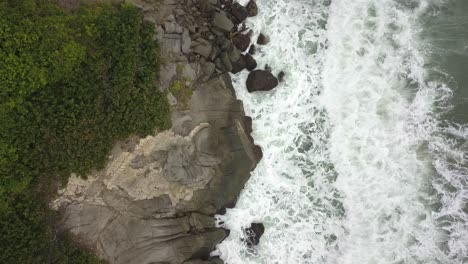 Wunderschöne-Drohnenaufnahme-Von-Wellen,-Die-Gegen-Die-Felsige-Küste-Des-Tayrona-Nationalparks-In-Kolumbien-Krachen