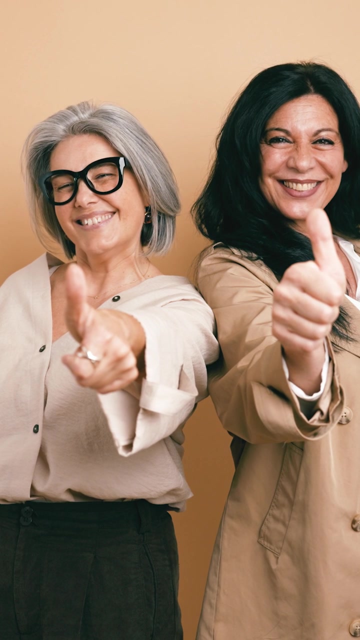 Two Mature Women Smiling and Giving Thumbs Up