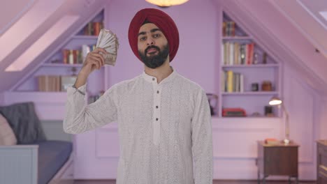 egoísta hombre indio sikh usando el dinero como ventilador