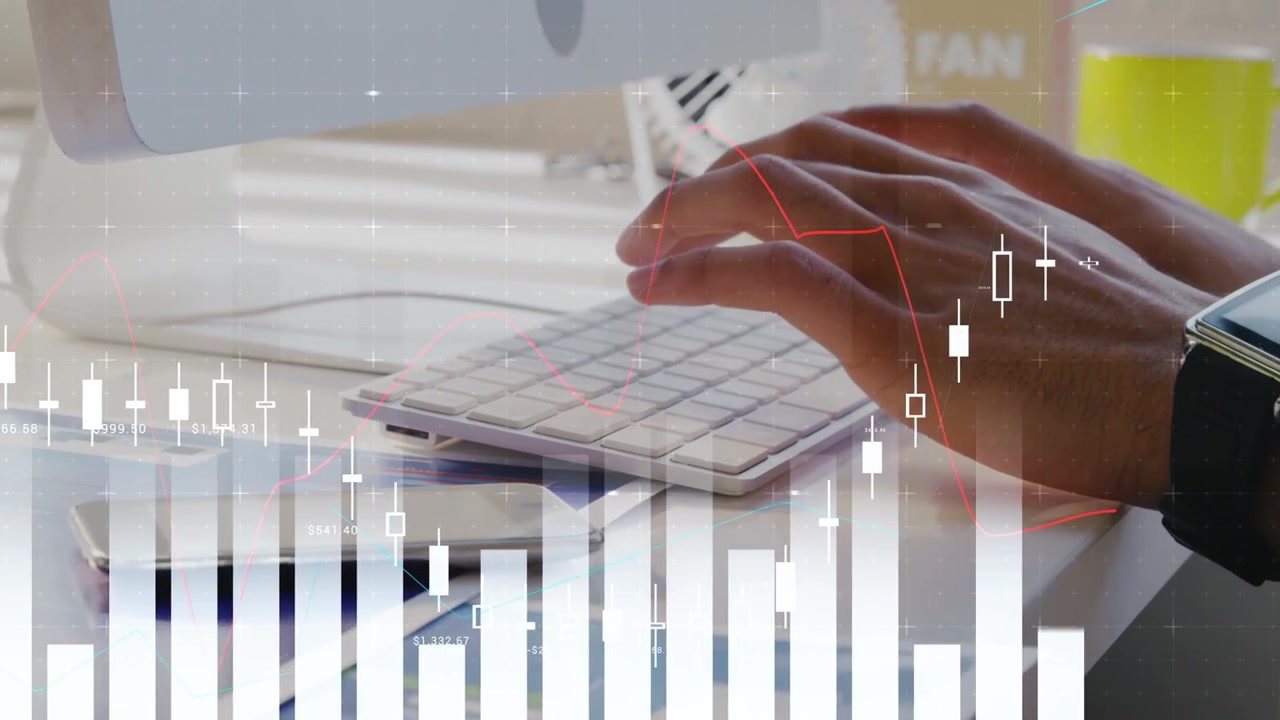 Mano destra che si avvicina alla tastiera mentre le mani digitano alla scrivania, aggiornando grafici finanziari animati in crescita