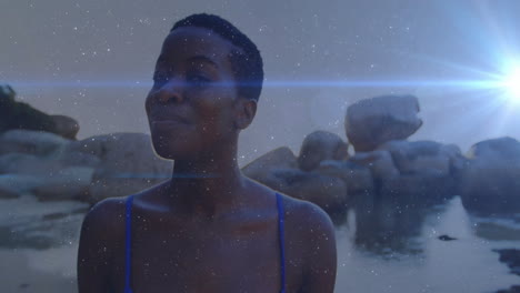 wearing blue swimsuit, woman with sparkling animation effect over rocky background
