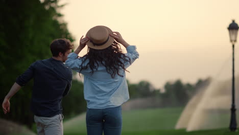 positive couple spending time together on walk. man and woman jumping in park