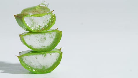 slices of fresh green aloe vera plant stacked pieces of leaves with transparent extract gel flows through the ingredients. natural medical plant for organic cosmetics, alternative medicine. vertical