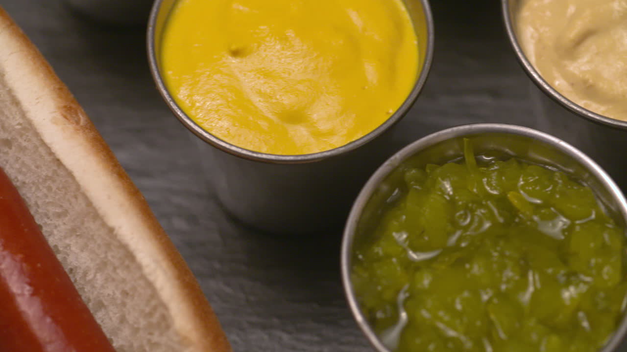 primer plano deslice a través de un jugoso perrito caliente con una variedad de condimentos