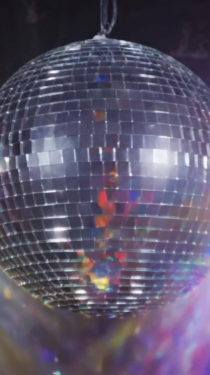 Riflessi Accattivanti: Una Scintillante Palla da Discoteca Proietta Luce su una Vivace Pista da Ballo tra Ritmi Energetici e Spettacoli Laser Colorati
