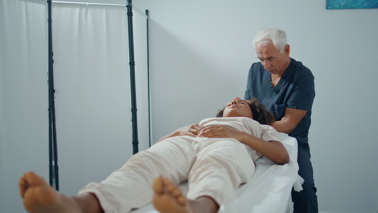 chiropraktiker heilt patientenverletzungen, massiert den kopf, reifer mann untersucht das problem