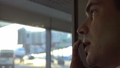 Man-having-phone-conversation-at-airport