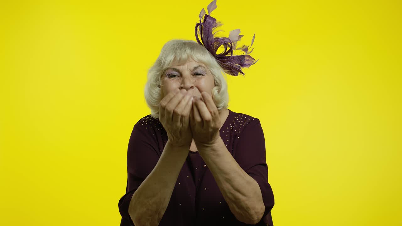 Anziana donna felice che manda baci volanti alla telecamera, dimostrando amore, emozioni romantiche