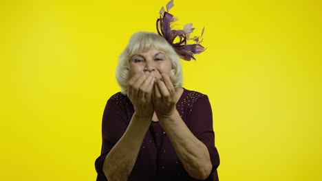 happy senior old woman sending air fly kisses to camera, demonstrating love, romantic emotions
