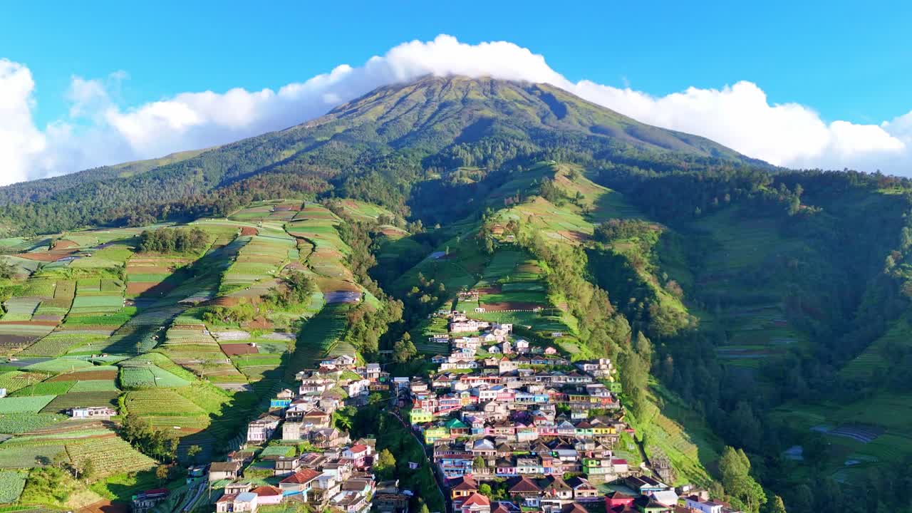 Vista aerea dell'incantevole villaggio Nepal van Java ai piedi del monte Sumbing. L'architettura vivace e colorata crea un bellissimo contrasto con il lussureggiante scenario montano verde.