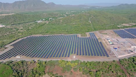 Wide-aerial-view-of-solar-farm-with-rows-of-PV-panels-in-middle-of-jungle