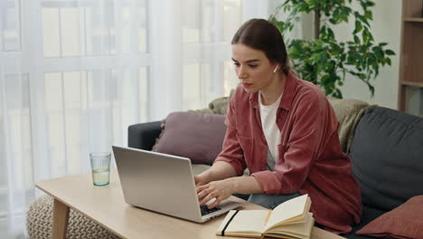 mujer trabajando desde casa en una computadora portátil
