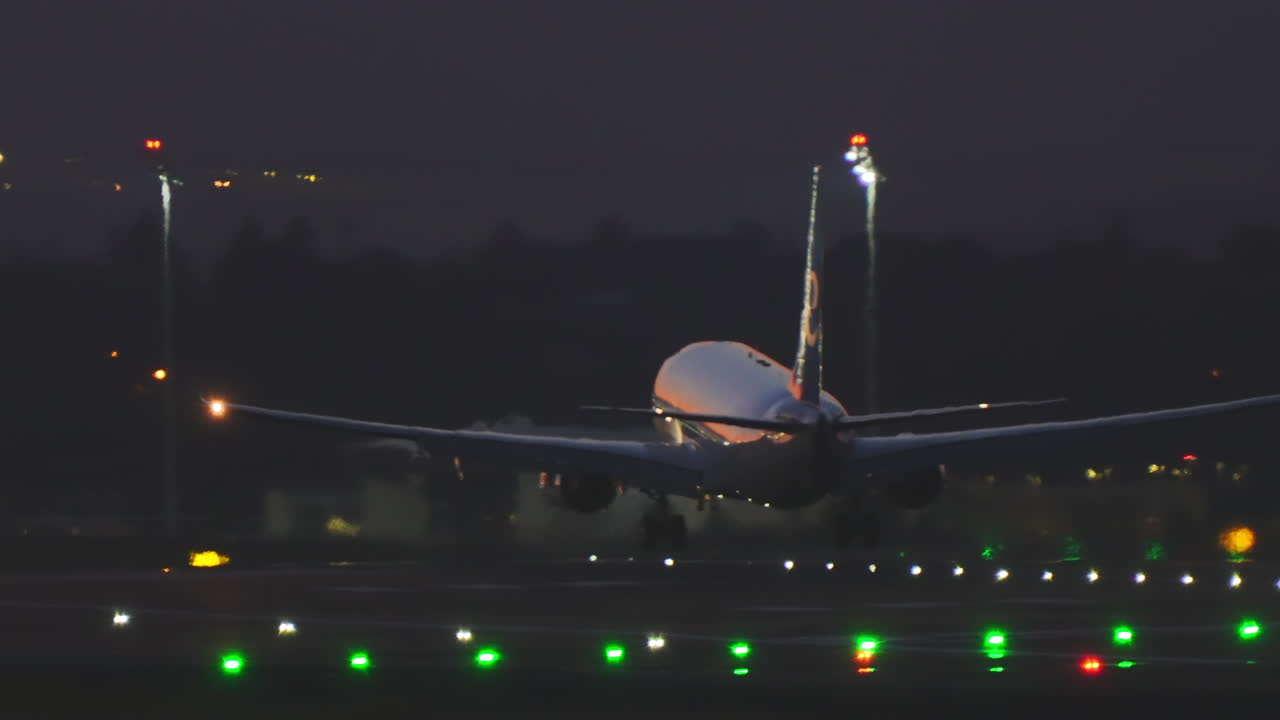Aereo di linea che atterra sulla pista al crepuscolo e di notte