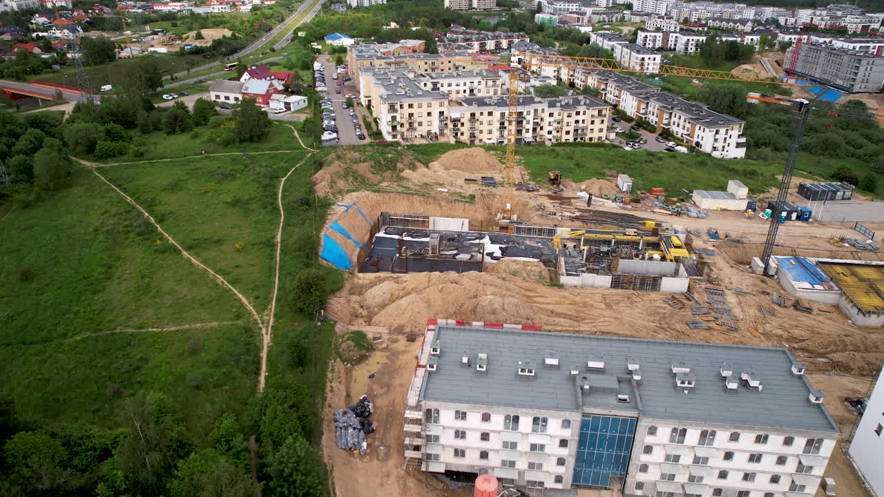 apartamentos-condominio edificios residenciales emergentes-área en el barrio de la ciudad de gdansk polonia, sitio de construcción y desarrollo urbano en terreno arenoso junto a la tierra verde y la ruta, vista aérea