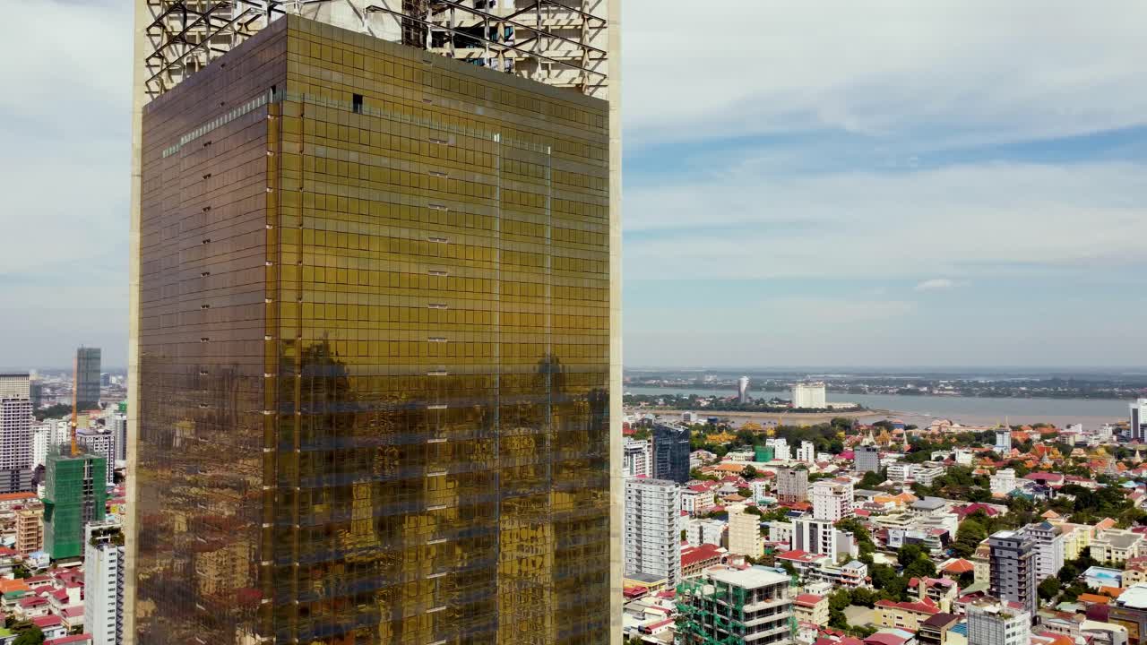 el famoso rascacielos de phnom penh, la torre de oro 42, la fachada de vidrio dorado, el barrio del bulevar preah sihanouk, tomada por un avión no tripulado, primer plano aéreo