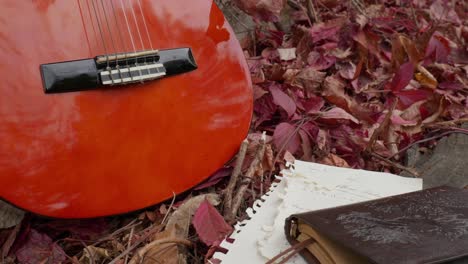 Escena-Del-Compositor,-Cuaderno-De-Letras-De-Guitarra-Acústica-Follaje-De-Otoño-Rojo