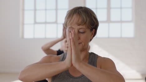 portrait yoga class beautiful mature woman exercising healthy meditation practicing prayer pose enjoying group physical fitness workout in studio