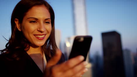 latin american businesswoman using mobile technology on rooftop