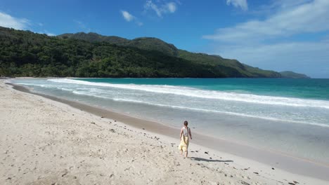 woman walking on one of the most beautiful beaches on earth - playa rincon in the dominican republic