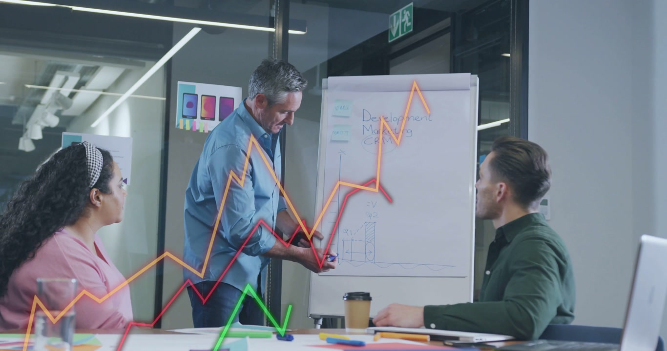 Vertical video: Presenting lead in blue shirt drawing at flip chart as meeting starts in glass room