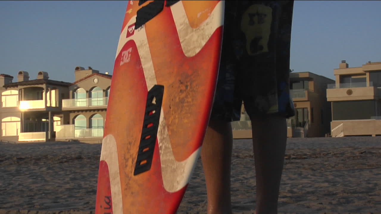 한 남자가 서핑보드를 들고 바다를 향해 달려간다