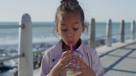 retrato hermosa niña bebiendo jugo sonriendo emocionada disfrutando de cálidas vacaciones de verano en la playa junto al mar