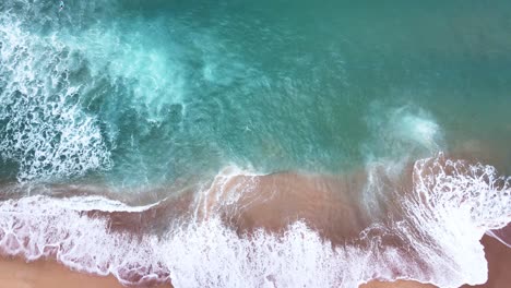 Luftaufnahme-Von-Meereswellen,-Die-Das-Strandufer-Erreichen